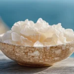 Fleur de Sel crystals in a ceramic bowl with a rustic background